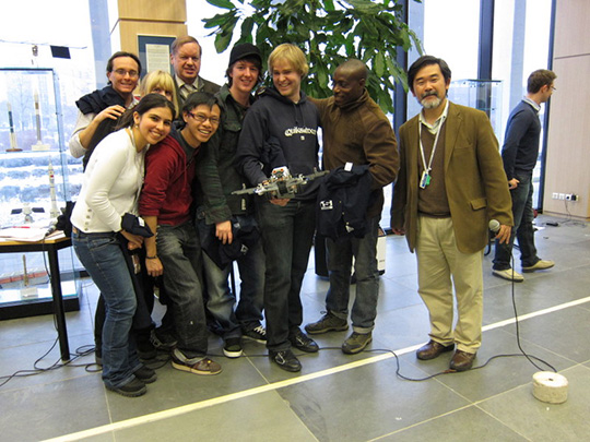 Figura 18 - Il professor Yoshida posa con il team vincitore della gara robotica.